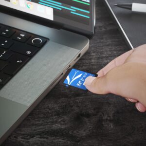 Sabrent Rocket V60 512GB SD card being inserted into a compatible laptop card slot