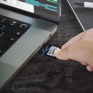 Sabrent Rocket V90 256GB SD card being inserted into a compatible laptop card slot