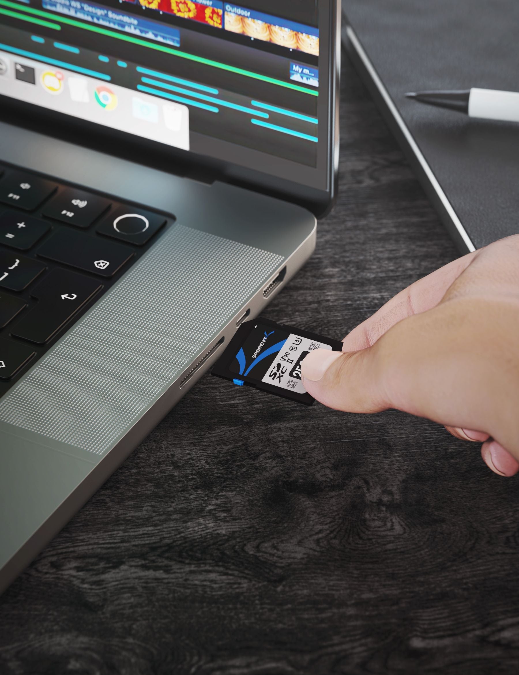 Sabrent Rocket V90 256GB SD card being inserted into a compatible laptop card slot